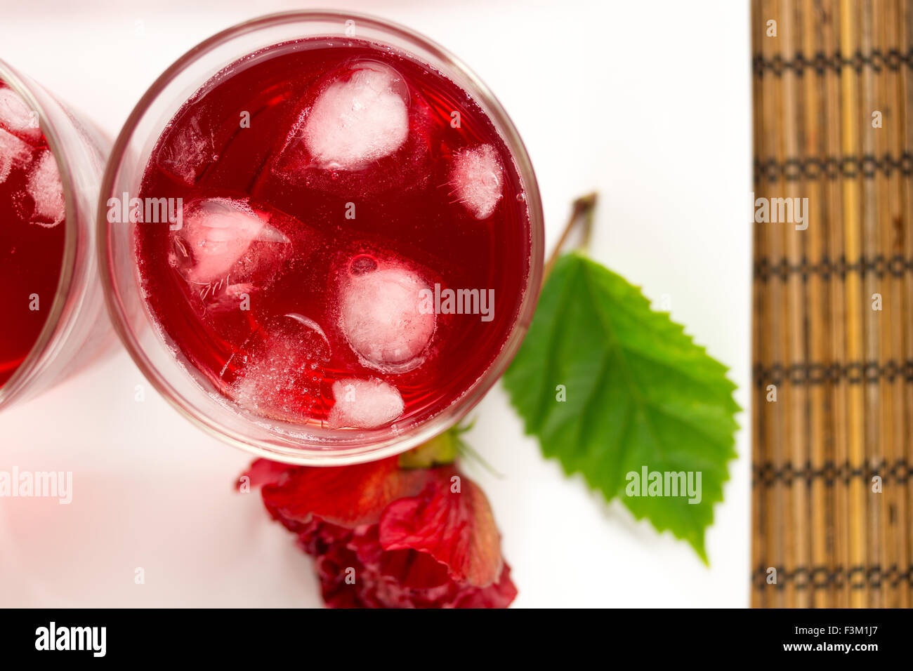 Rose and hibiscus flower iced tea served with ice cubes Stock Photo Alamy