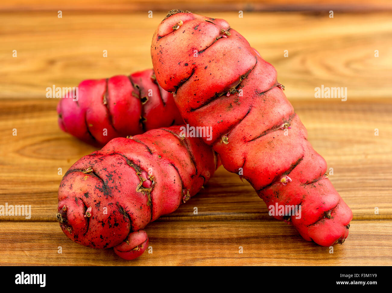 Fresh red new zealand yams (pink oca) on wood Stock Photo