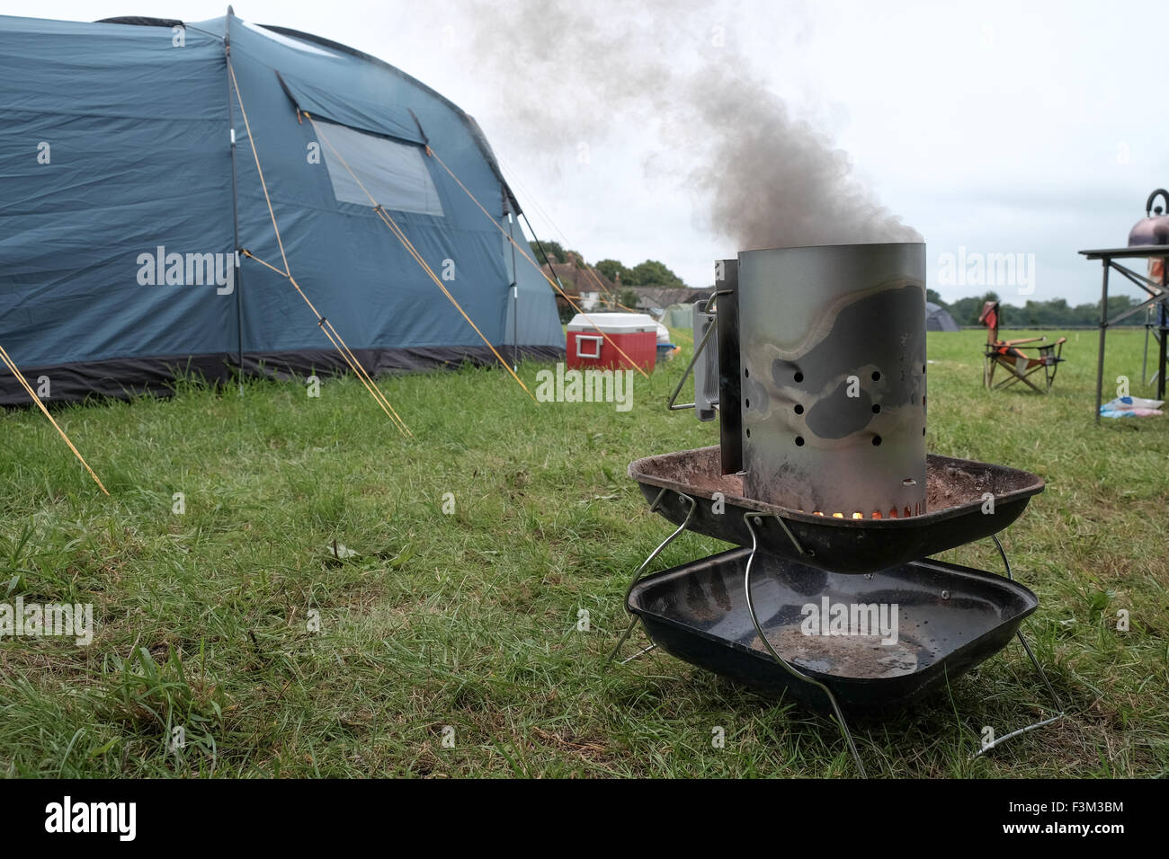 Chimney barbecue starter in use whilst camping Stock Photo Alamy
