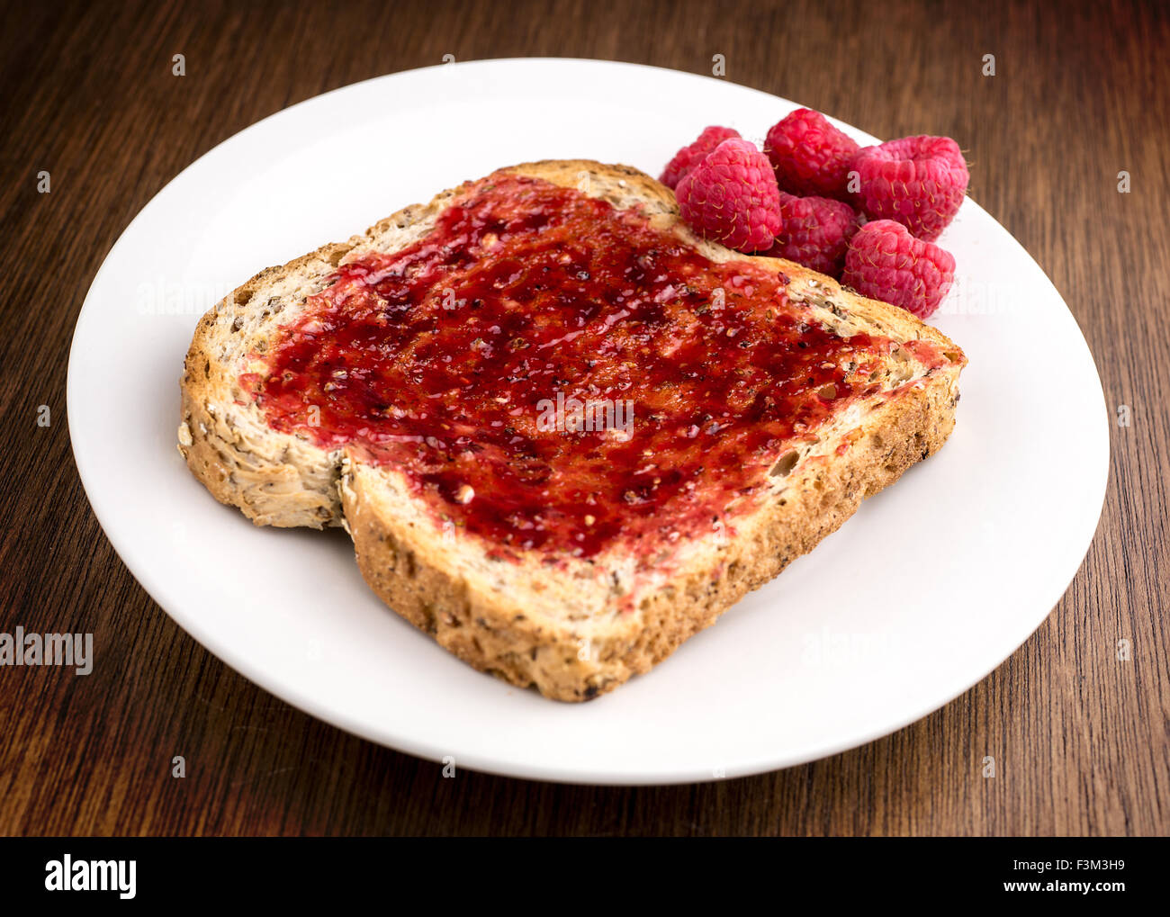 Tasty rasberry jam spread on whole wheat toast Stock Photo