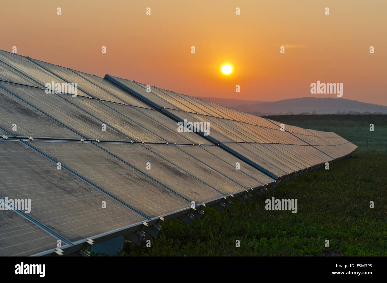Photovoltaik solar panels in a row at sunrise Stock Photo
