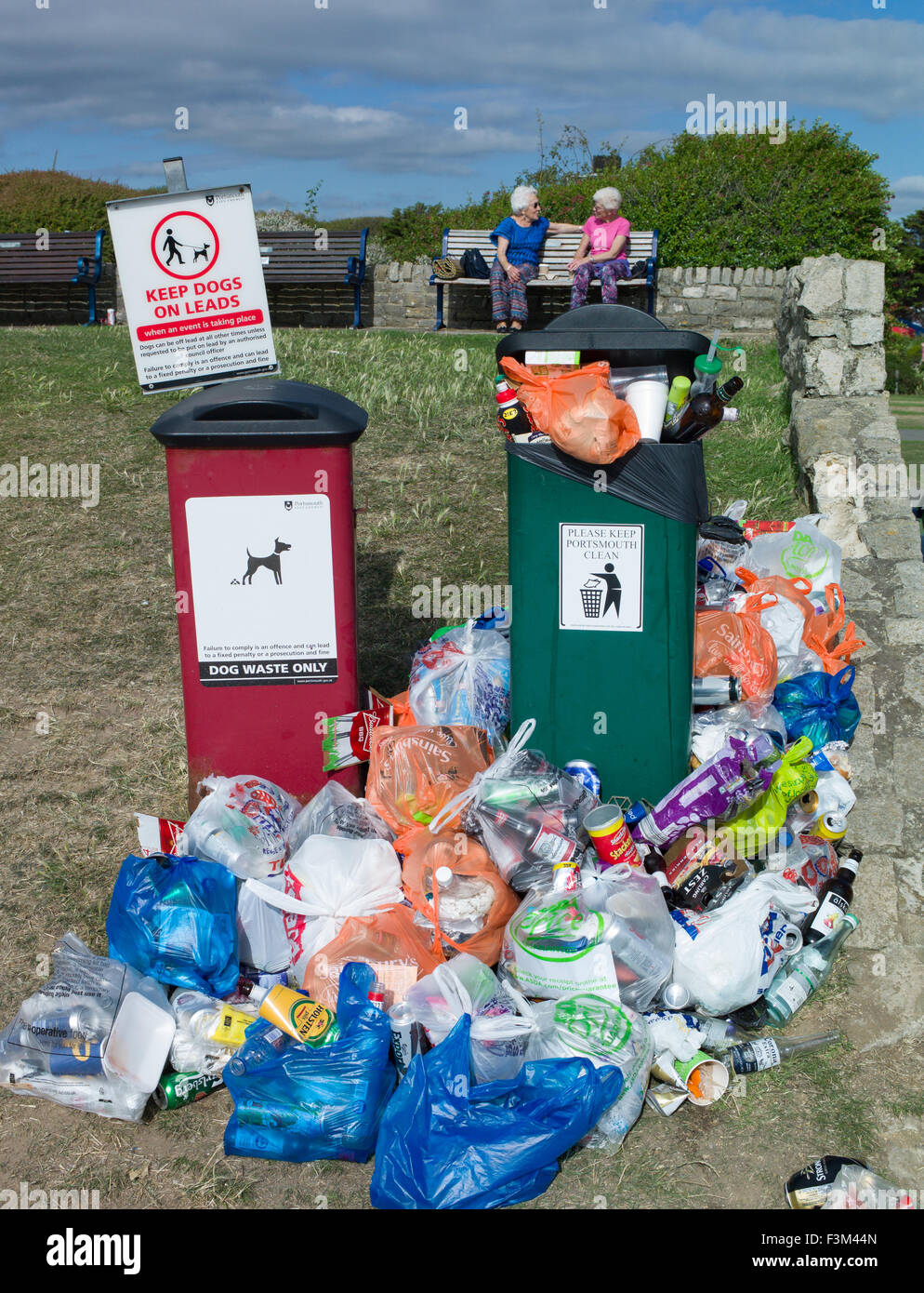 overflowing rubbish bins with plastic bags dumped around Stock Photo