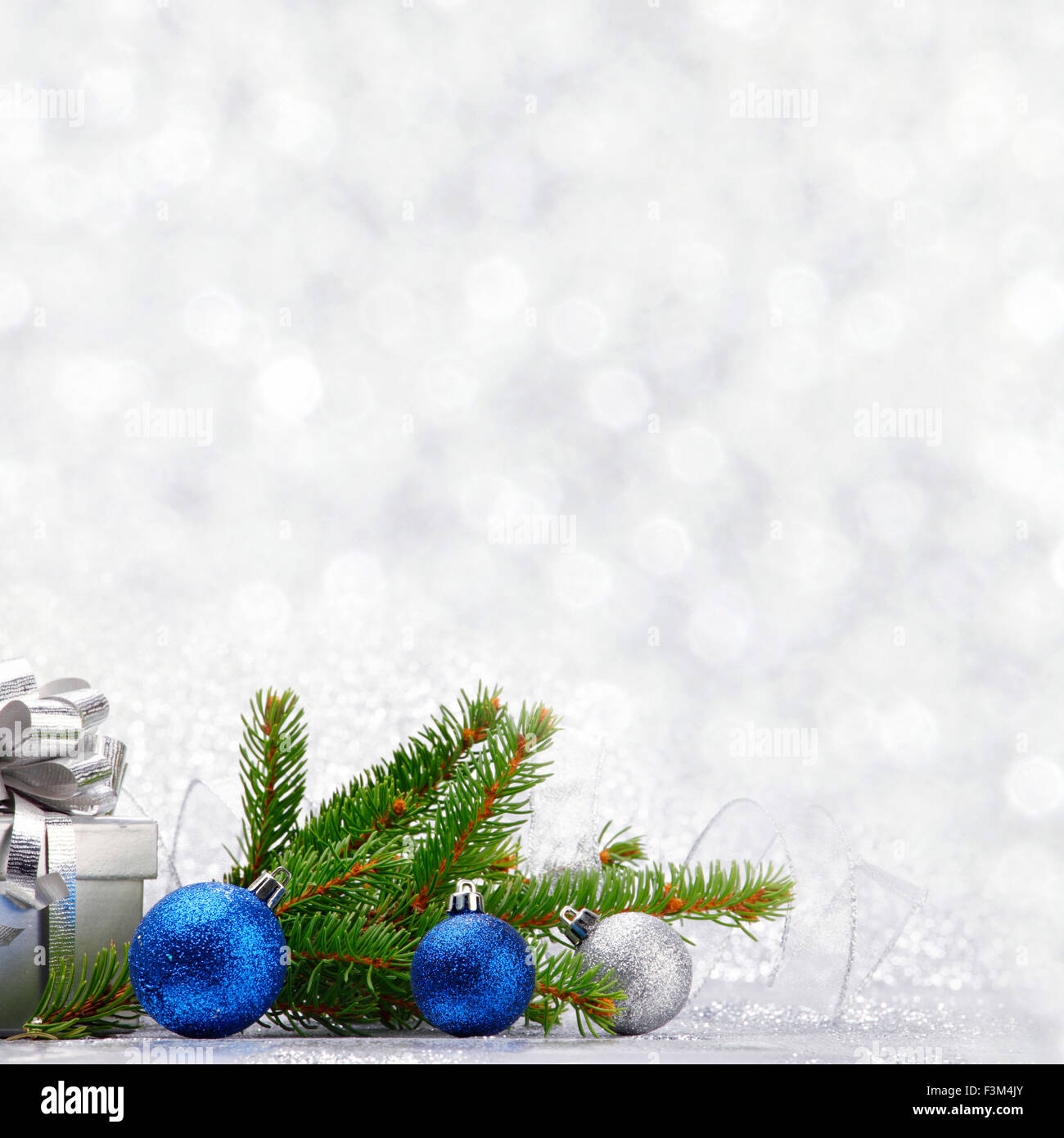 Christmas fir tree branch and decoration on silver glitter background ...