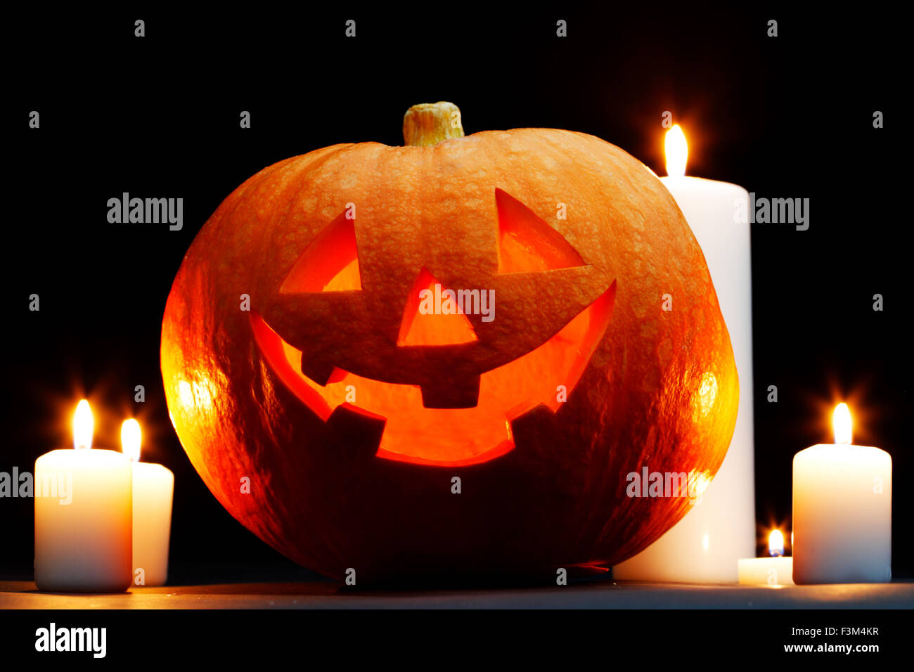 Halloween Jack O' Lantern pumpkin and candles on black background Stock ...