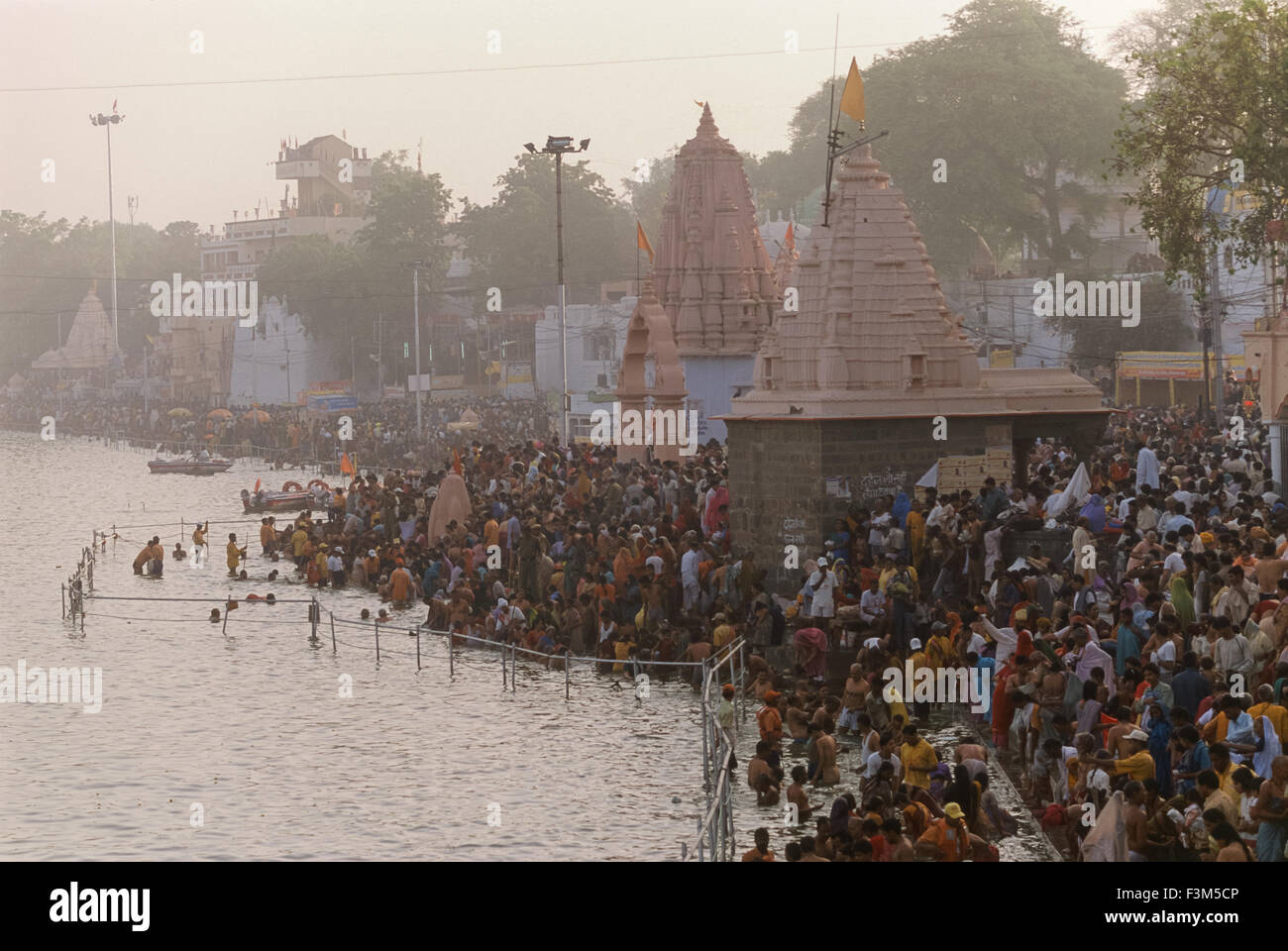 Bathing pilgrims thronging the ghats of the Shipra River at sunrise, Simhastha Kumbh Mela 2004, Ujjain, Madhya Pradesh, India Stock Photo