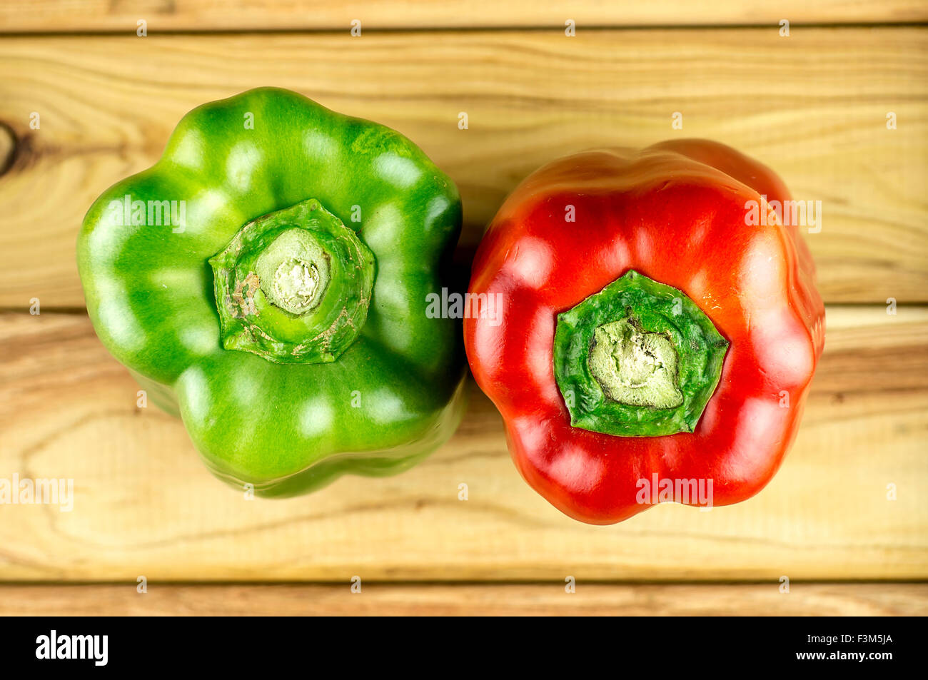 Aerial of green and red bell peppers on cutting board Stock Photo