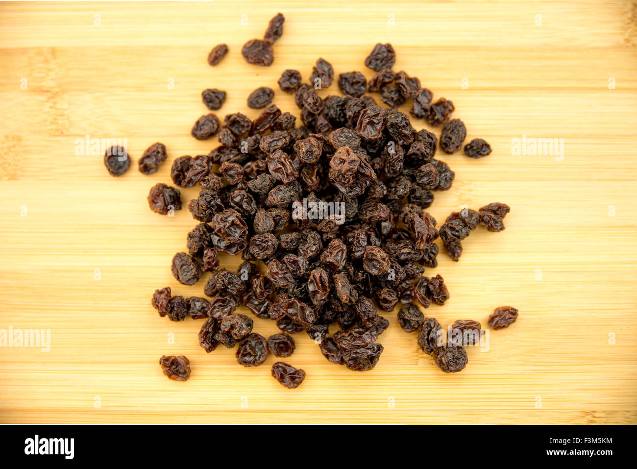 A pile of sweet dried raisins on a wooden cutting board Stock Photo - Alamy