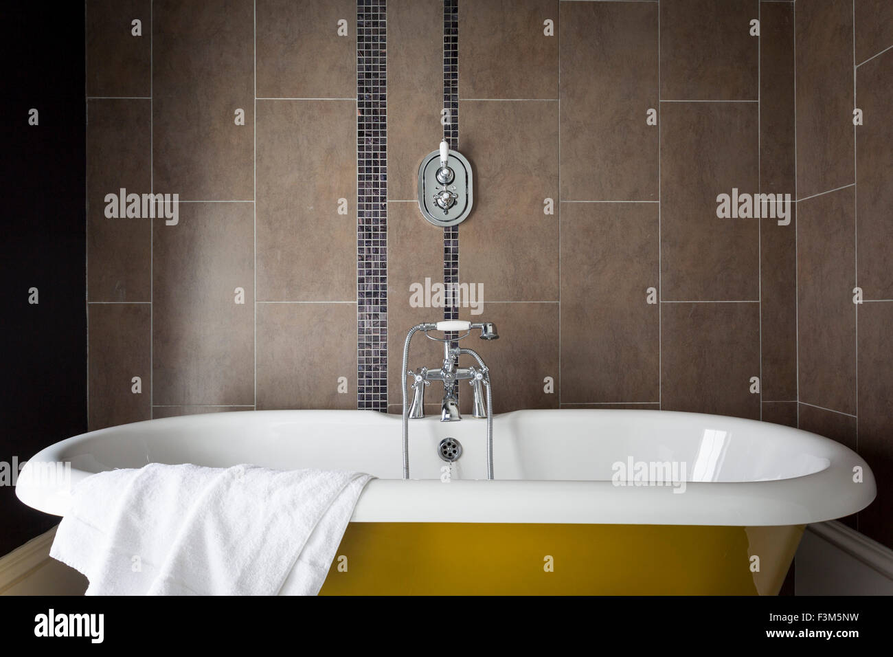 Roll top bath in luxurious bathroom with tiled walls Stock Photo