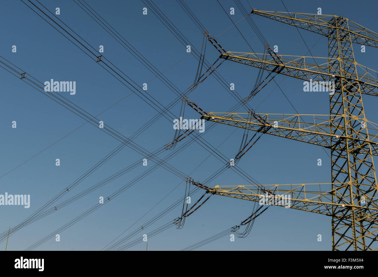 Overhead powerline in front of blue sky Stock Photo
