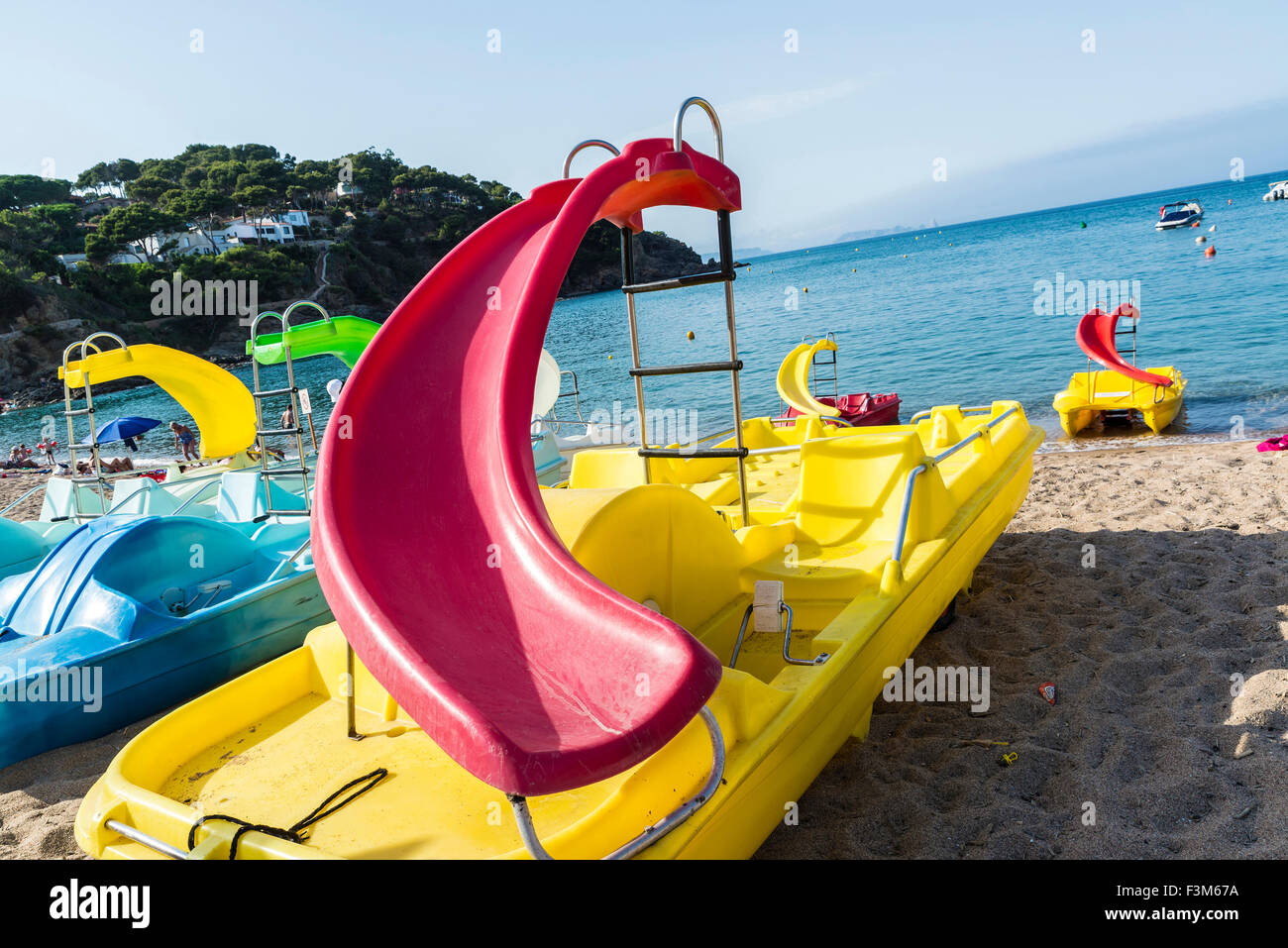 Colorful pedalos with slides on the beach of Sa Riera in Costa Brava