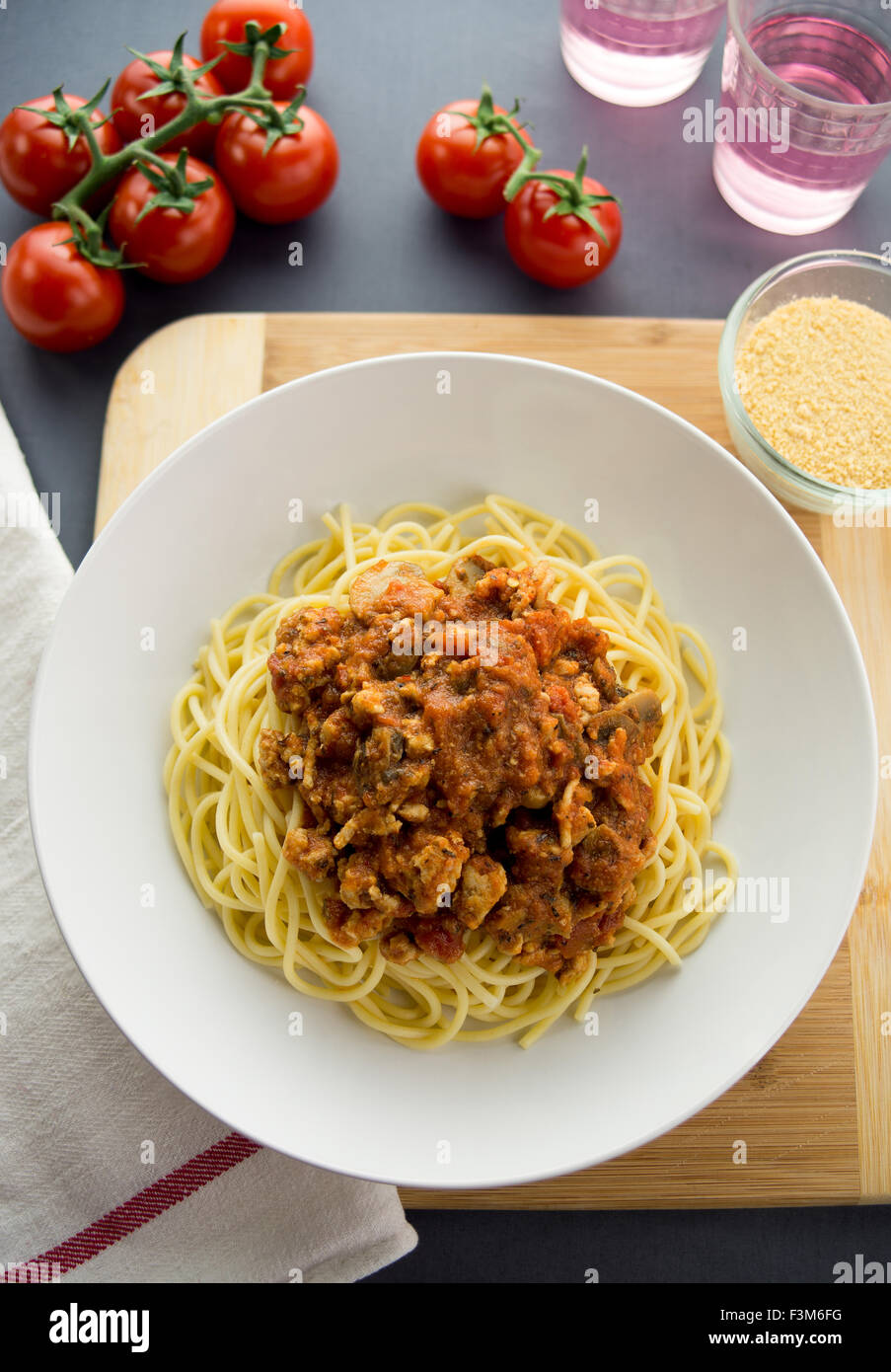 Bolognese sauce made with ground chicken served on top of spaghetti pasta in a white bowl. Aerial view with ingredients and cond Stock Photo