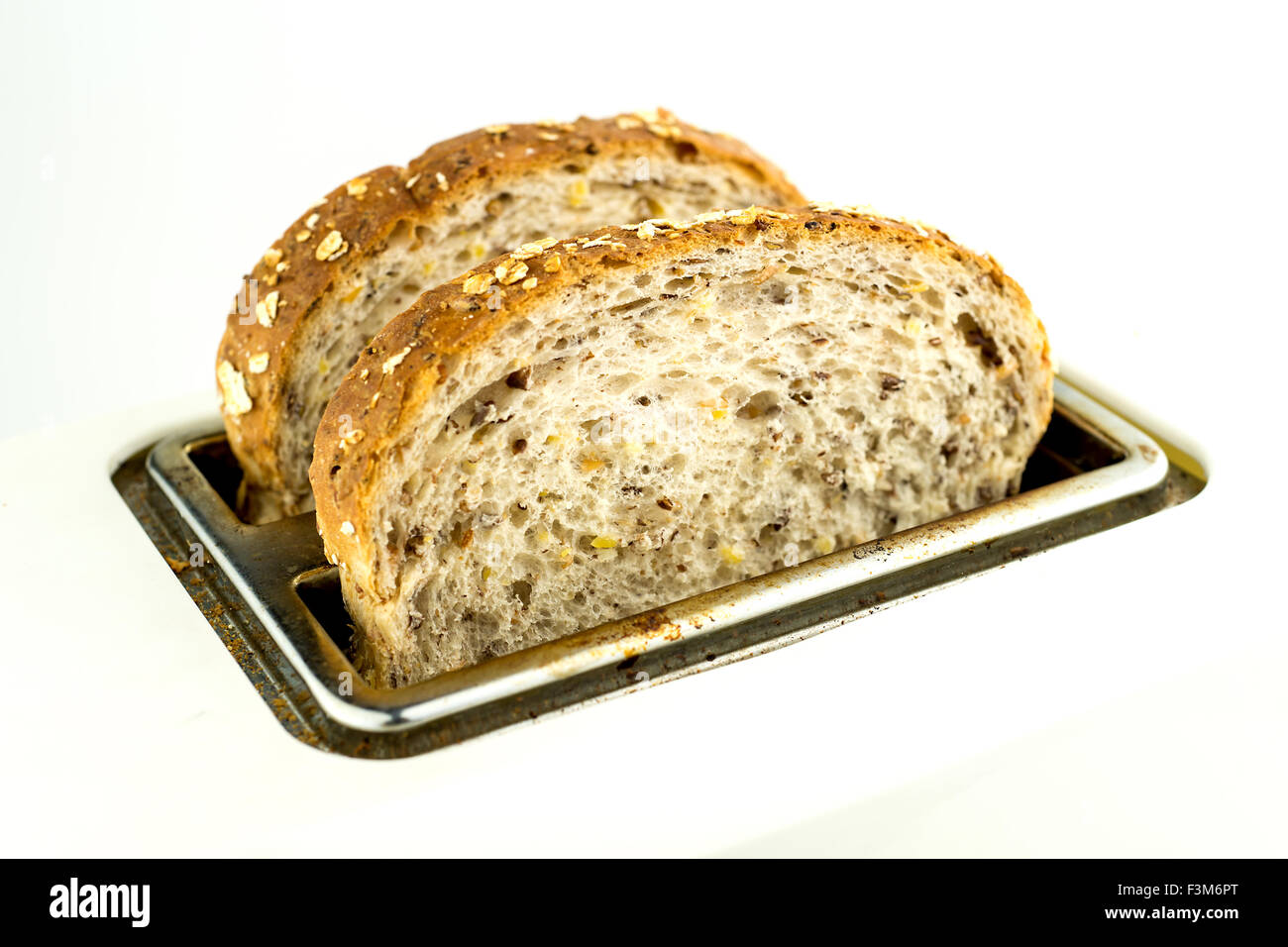Whole wheat bread in toaster isolated Stock Photo