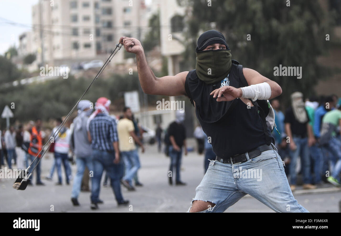 (151009) -- RAMALLAH, Oct. 9, 2015 (Xinhua) -- A Palestinian protester hurls stones at Israeli soldiers, during clashes in Beit El on the outskirts of the West Bank city of Ramallah, on October 9, 2015. Medics reported that 6 protesters injured with live ammunition, other 20 with rubber bullets. (Xinhua/Fadi Arouri) (azp) Stock Photo