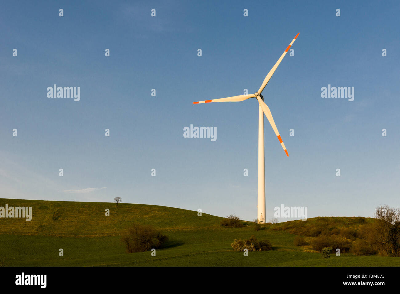 A wind power plant is in use in a hilly landscape Stock Photo