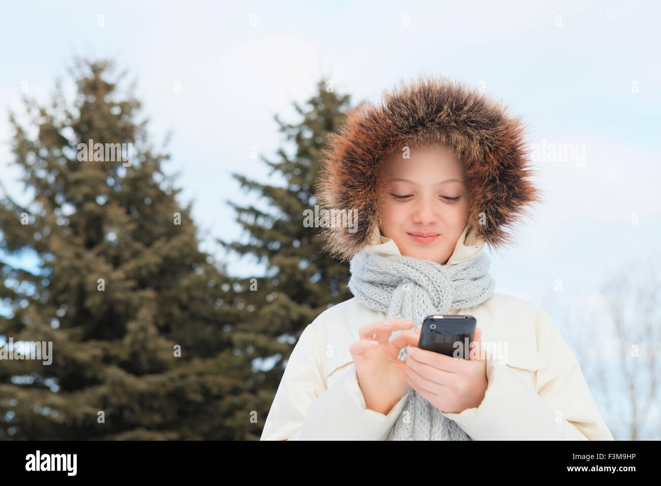 Winter,Hood,Teenage Girl,Texting,Smart Phone Stock Photo