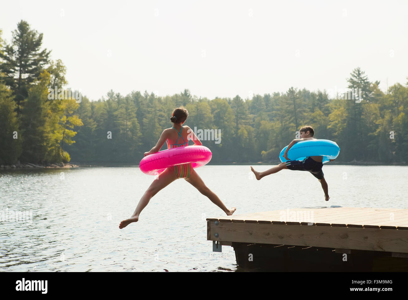 Girl,Jetty,Jumping,Ring,Inflatable,Boy,Lake Stock Photo