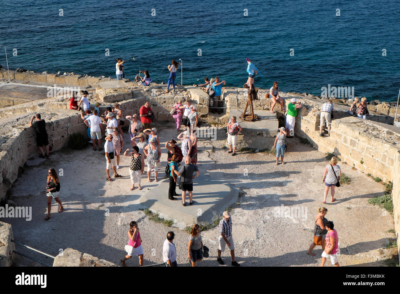 Tourists enjoy the late afternoon light on the coast at Kyrenia harbor in North Cyprus  KATHY DEWITT Stock Photo