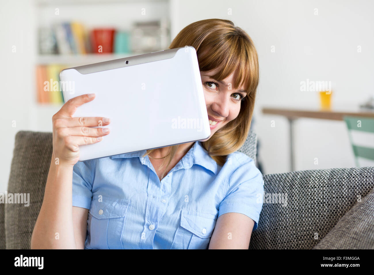 Funny woman with digital tablet in modern apartment. Playing with the camera Stock Photo