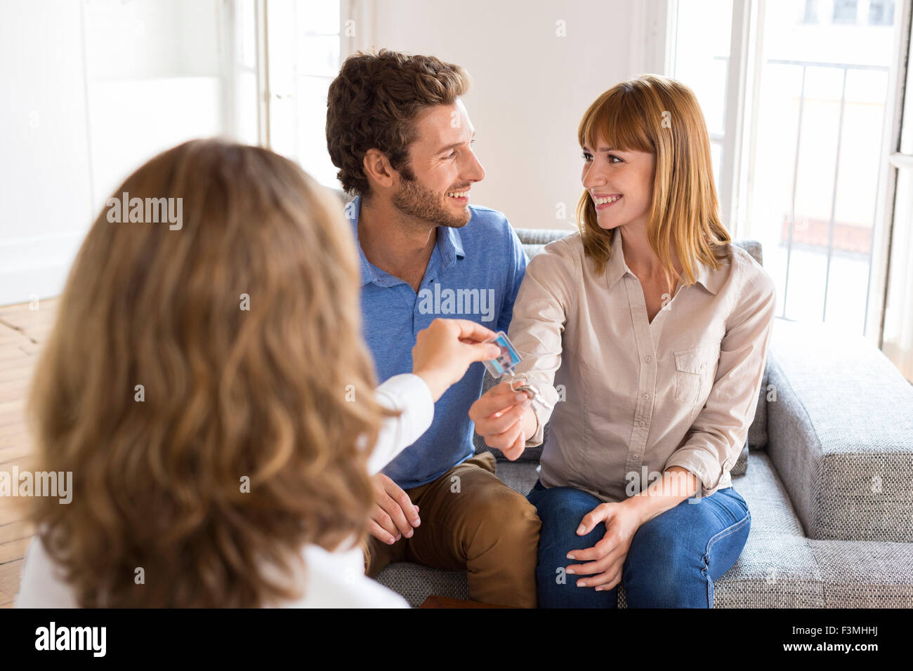 Real estate agent giving house keys to new owners Stock Photo - Alamy