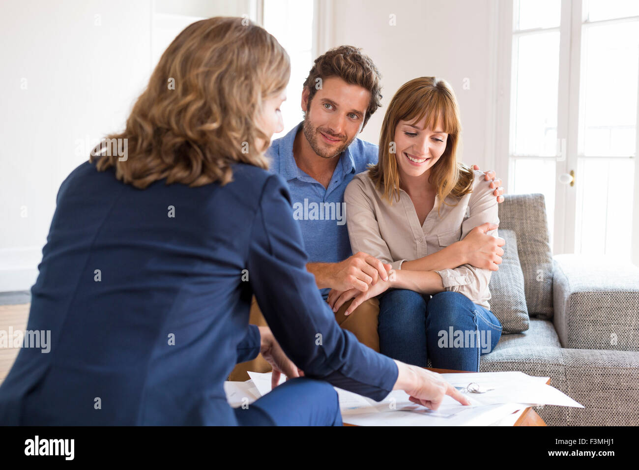Realtor agent presenting a contract for apartment investment to future owners couple Stock Photo