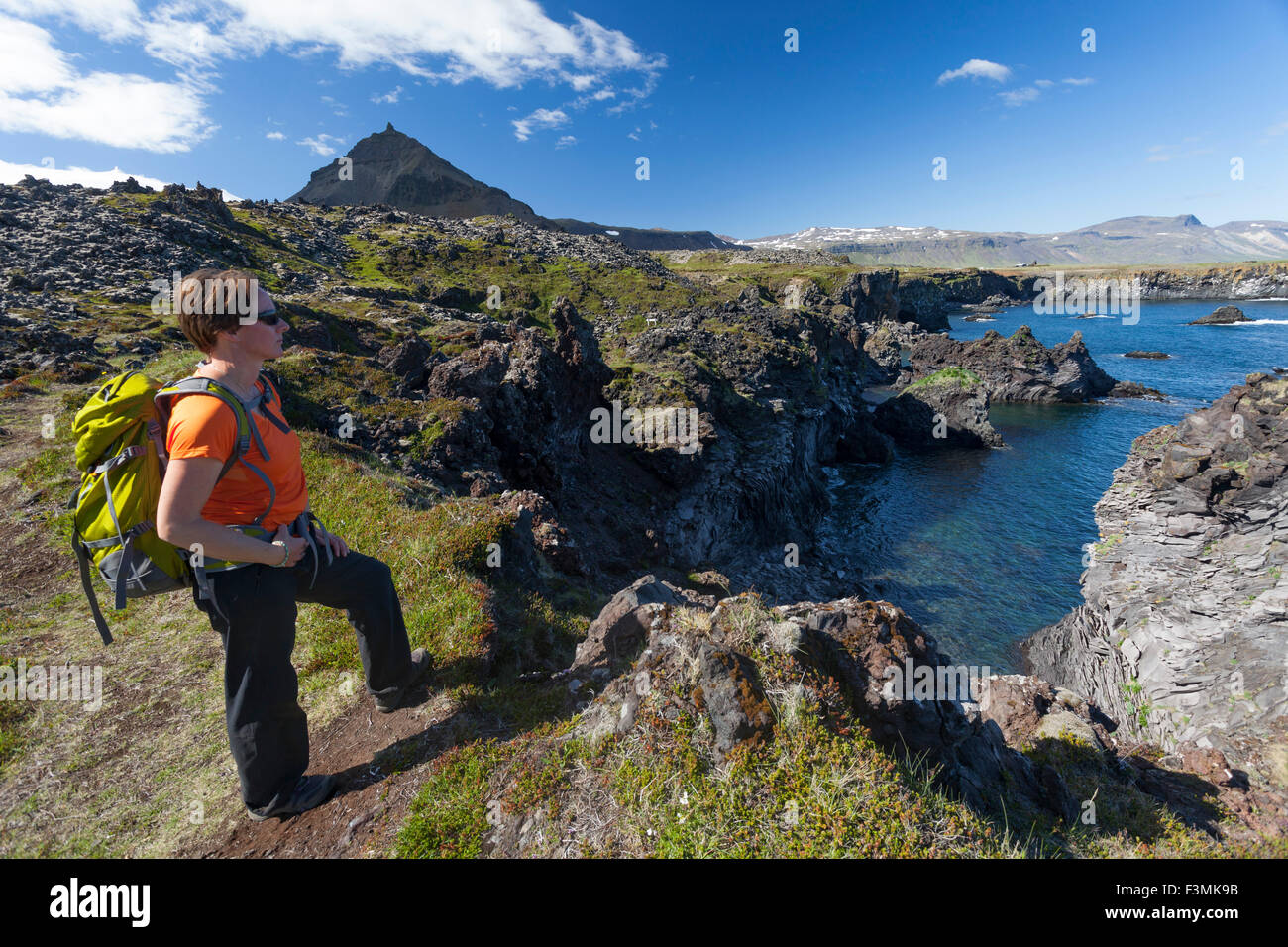 Hiker on the Hellnar-Arnarstapi coastal path, Snaefellsnes Peninsula, Vesturland, Iceland. Stock Photo