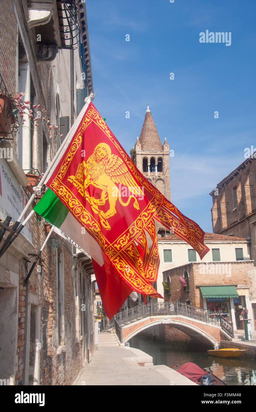 Venetian flag with Lion of St Mark, with canal and tower of San Barnaba church in background Dorsoduro Venice Veneto Italy Stock Photo