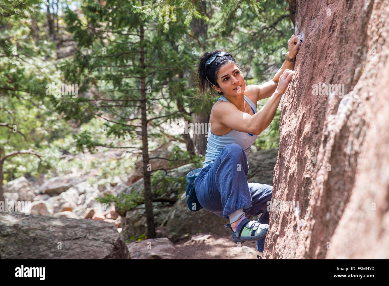 Strong female looking towards next move on a boulder problem Stock Photo