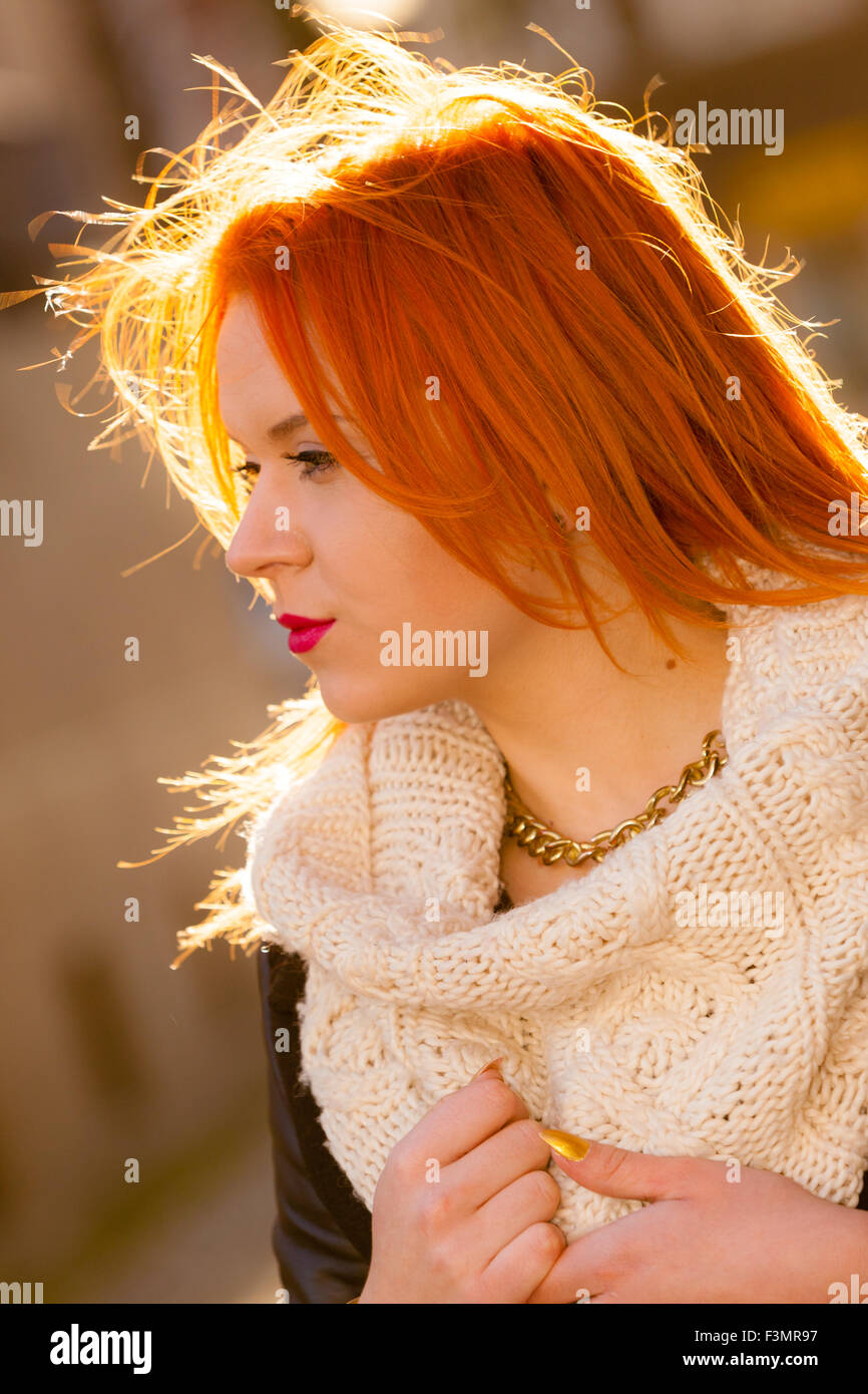 Winter fashion. Beauty face portrait redhaired young woman in warm clothing outdoor enjoying sunlight on sunny day. Stock Photo
