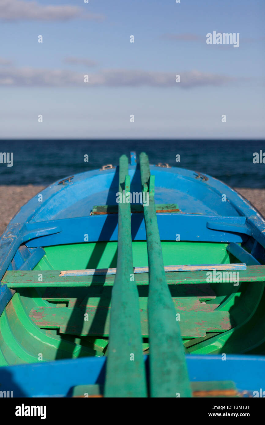 Blue and green wooden boat with wooden oars Stock Photo