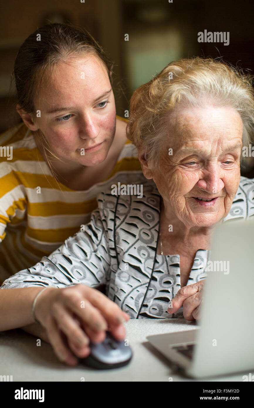 Granddaughter teaches her grandmother to work on the computer. Stock Photo