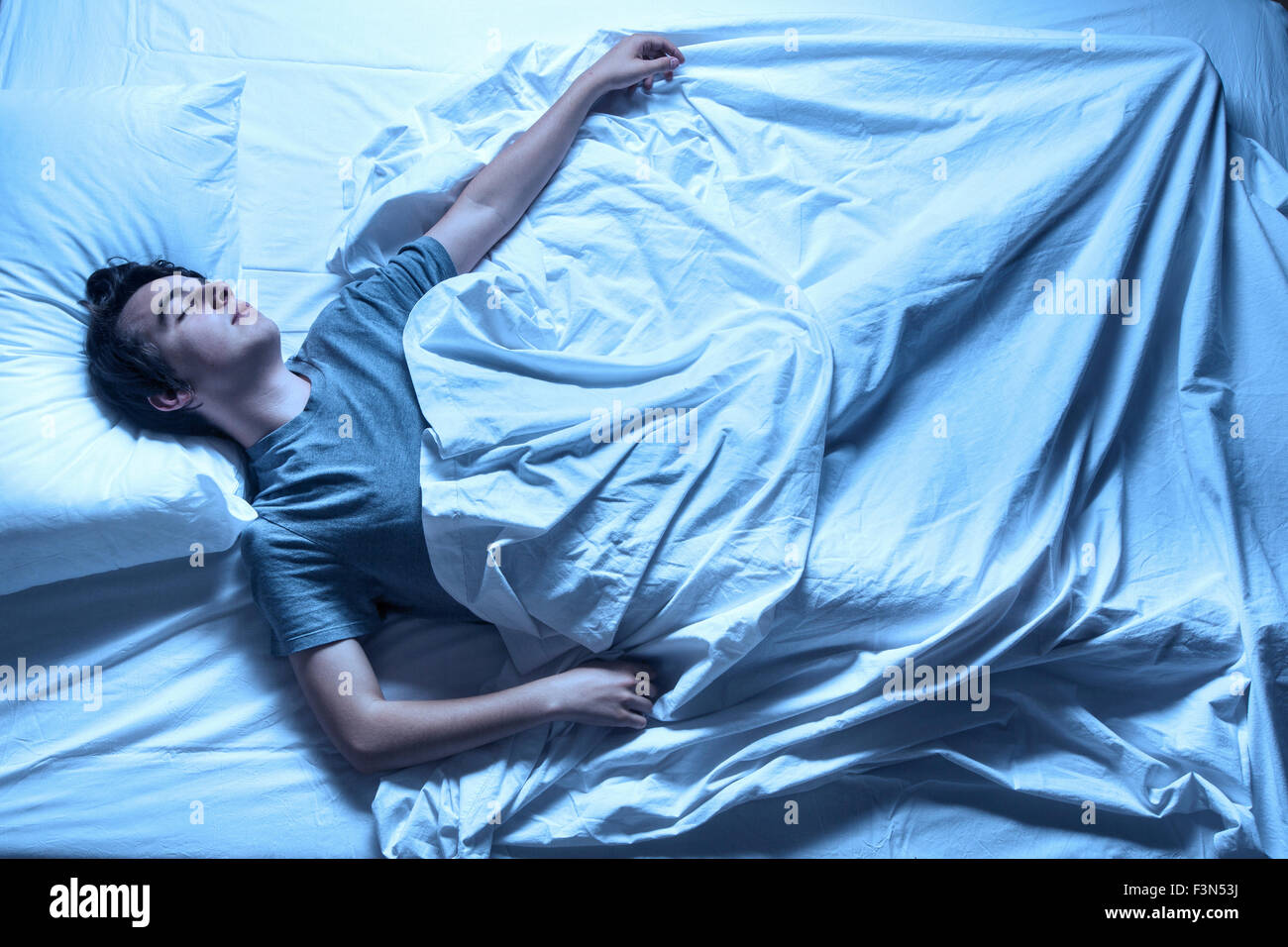 Man asleep in a bed Stock Photo