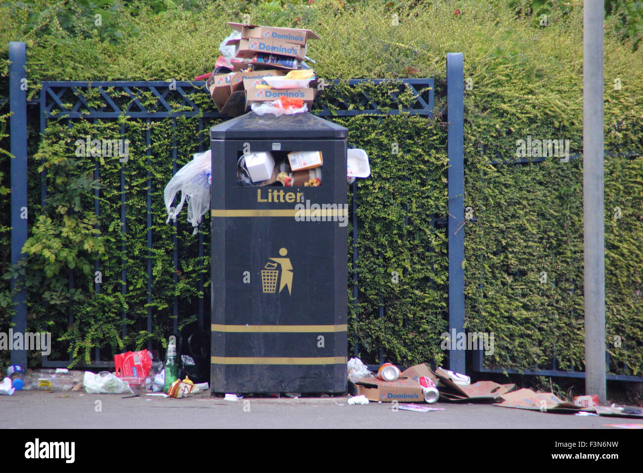 A litter bin overflows with rubbish on a street in Sheffield, South Yorkshire, England UK Stock Photo