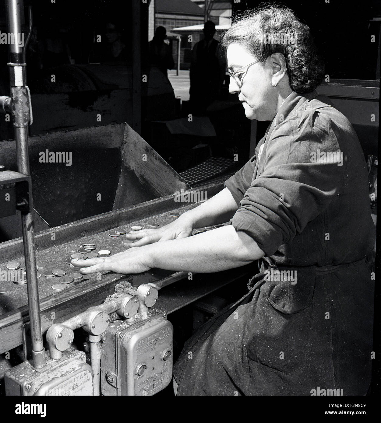 Historical, 1950s, female operative checking parts on a conveyor belt ...