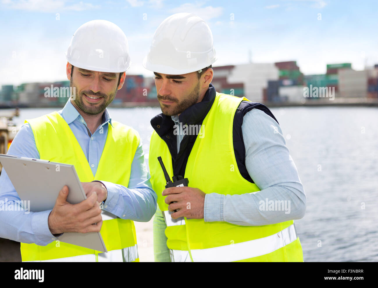 View of a Dock worker and supervisor checking containers data Stock
