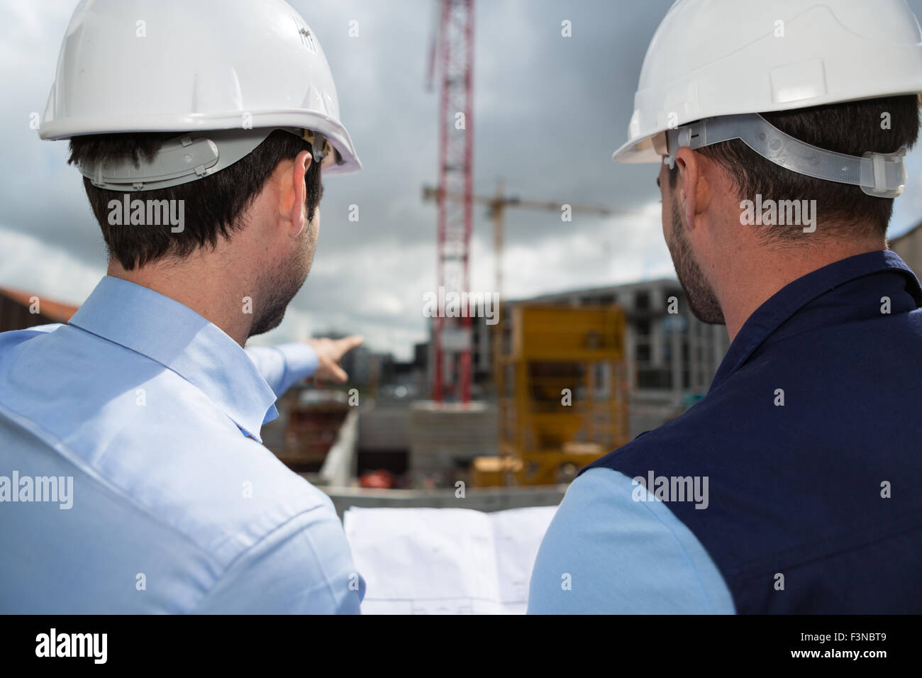 View of a Engineer and worker checking plan on construction site Stock ...