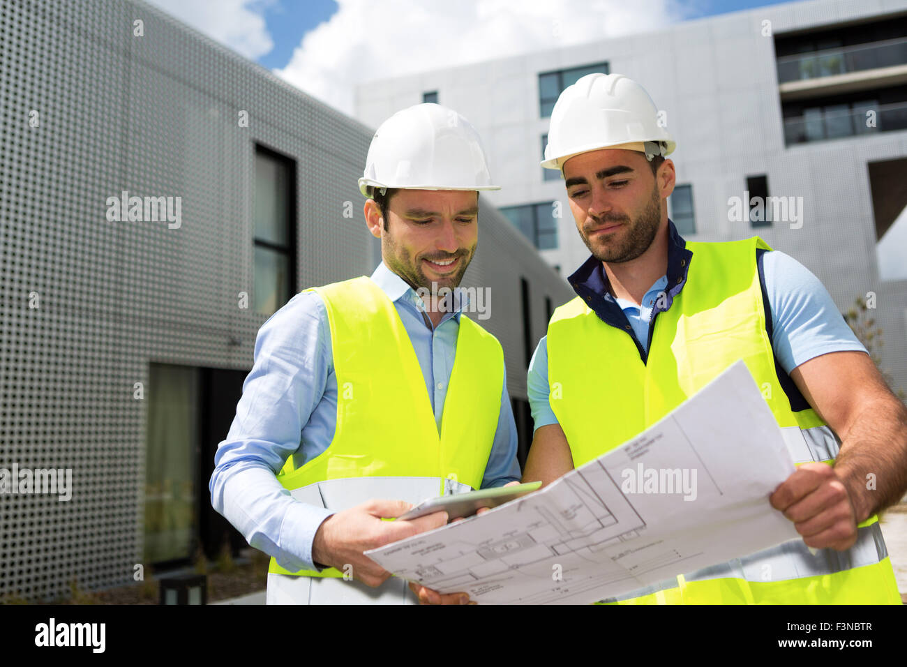 View of a Engineer and worker checking plan on construction site Stock ...