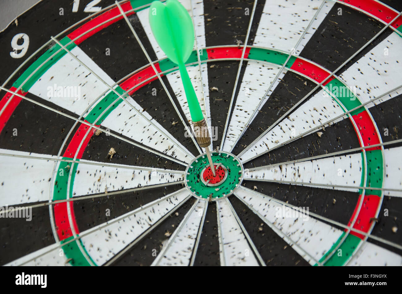 dart hitting bullseye on dartboard Stock Photo