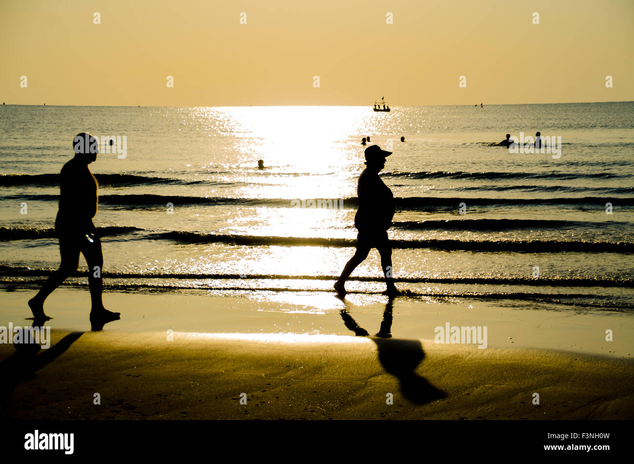 silhouette of senior couple walking on the beach Stock Photo - Alamy
