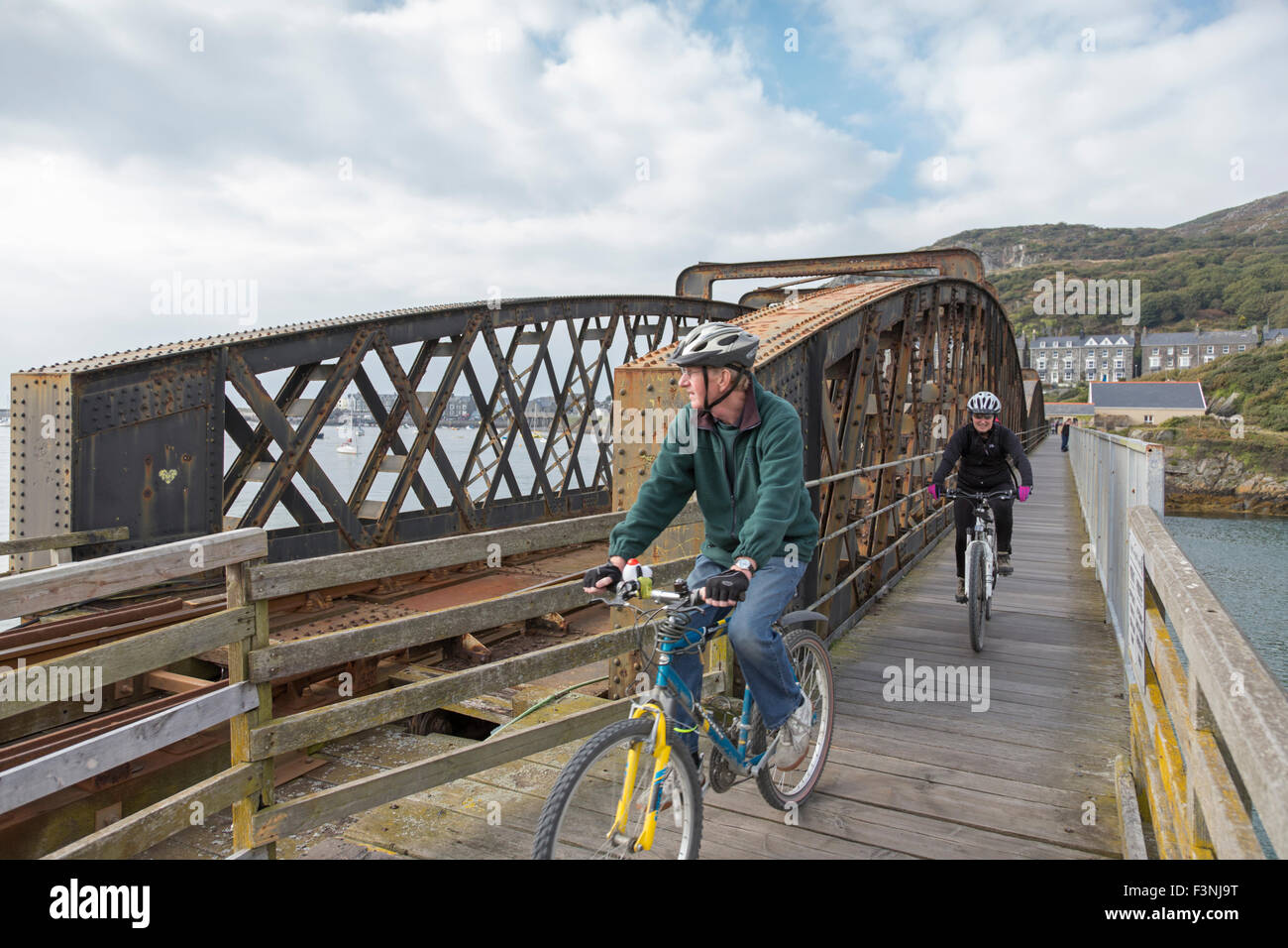 Cyclists on Barmouth Bridge also known as Barmouth Viaduct crossing the Mawddach estuary, Gwynedd, Wales, UK Stock Photo