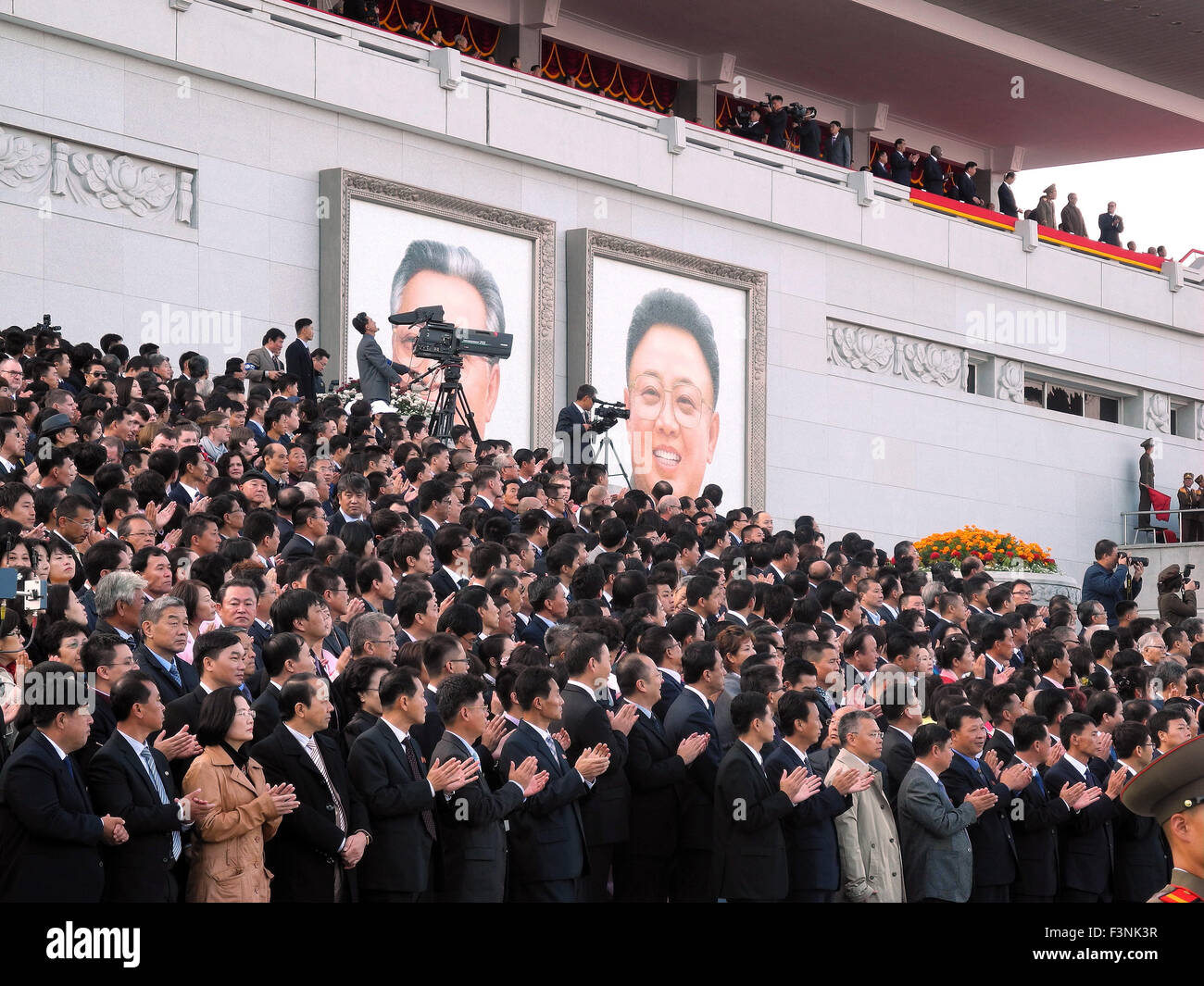 Pyongyang, North Korea. 10th Oct, 2015. Guests applaud in the stands during the military parade for the 70th anniversary of the founding of the ruling workers' party on Kim Il-Sung Square in Pyongyang, North Korea, 10 October 2015. Photo: JOERN PETRING/dpa/Alamy Live News Stock Photo