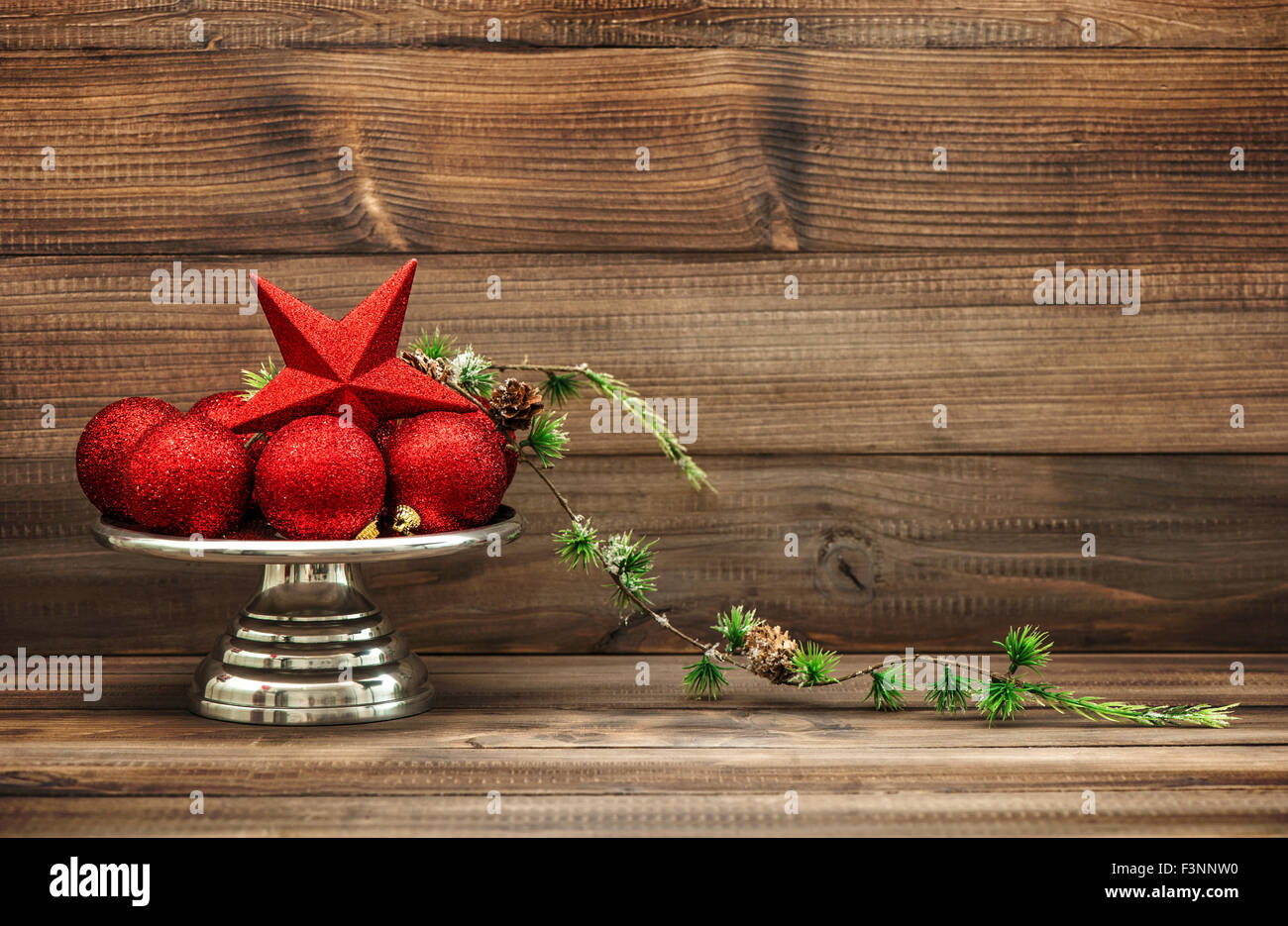Christmas decoration with red baubles on rustic wooden background. Retro style toned picture. Vintage still life Stock Photo