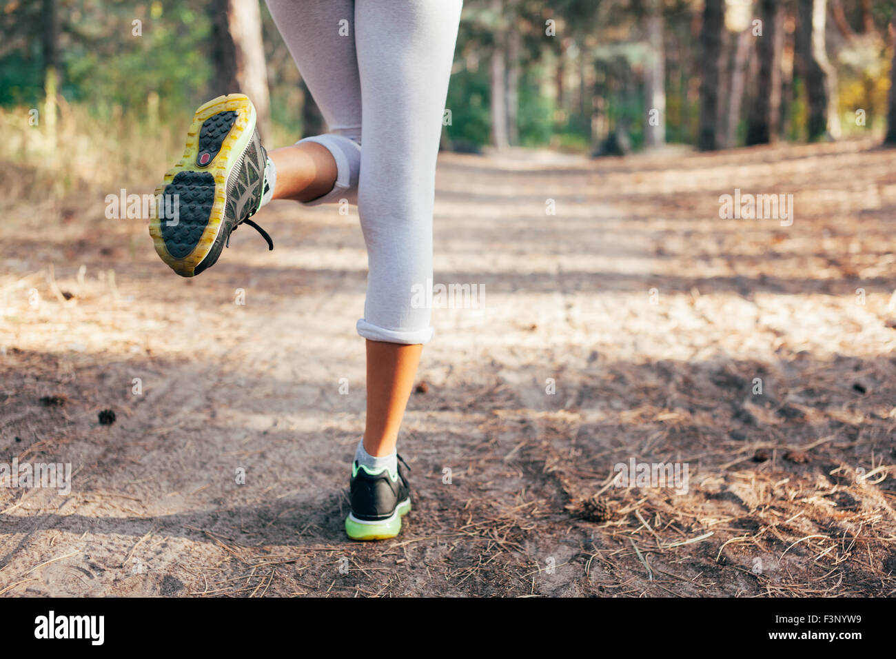 Runner feet running on road close-up on shoe. woman fitness at sunrise Stock Photo