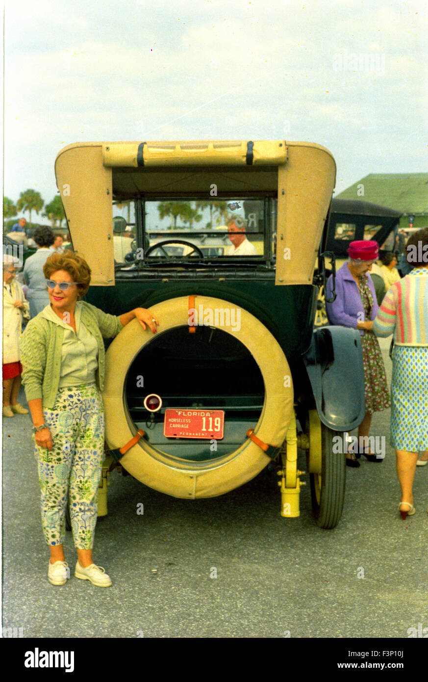 woman posing next to early sports car at 1960s car show in Florida Stock Photo