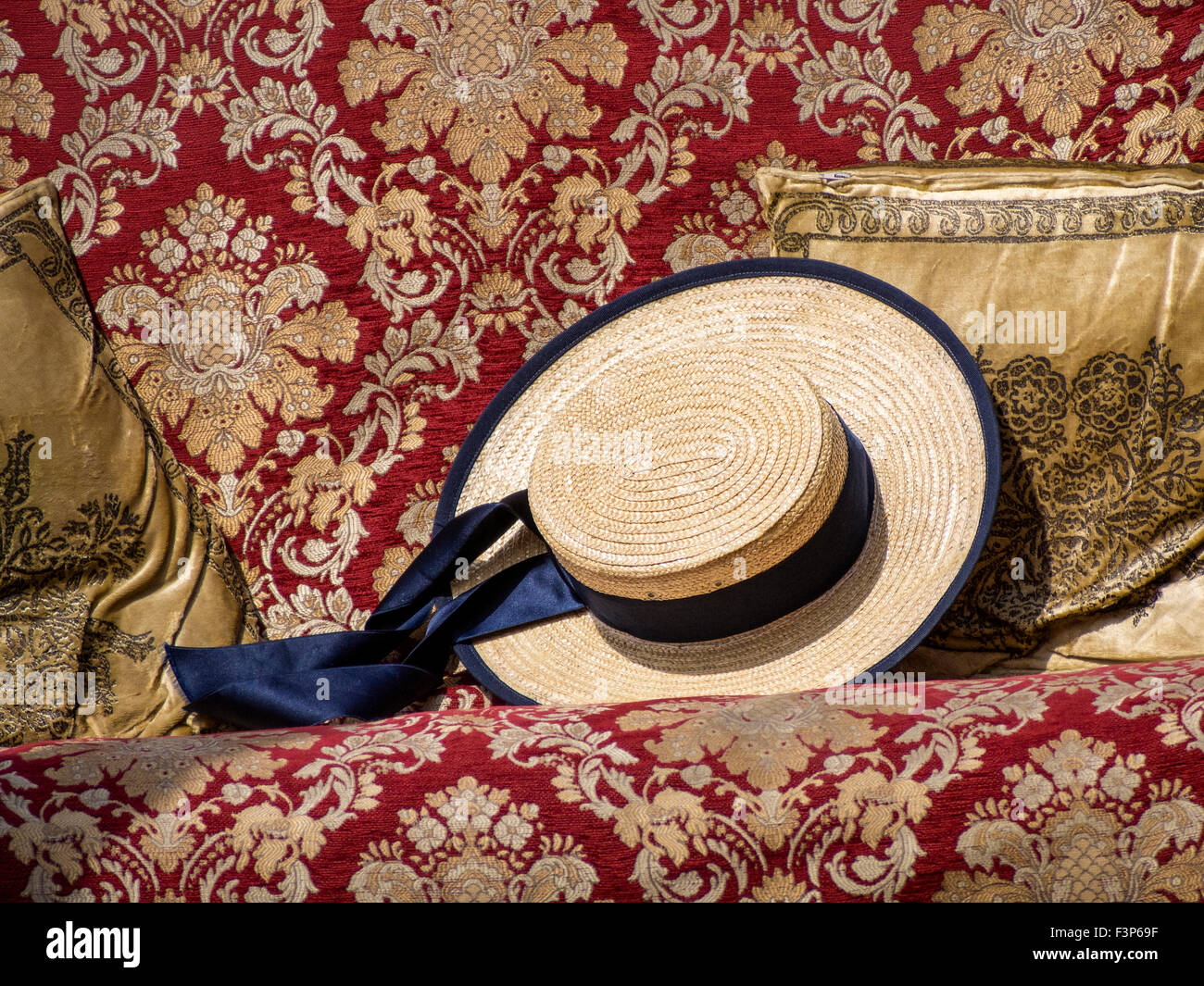 VENICE, ITALY - MAY 05, 2015:  Traditional straw hat belonging to Gondolero on seat in Gondola Stock Photo