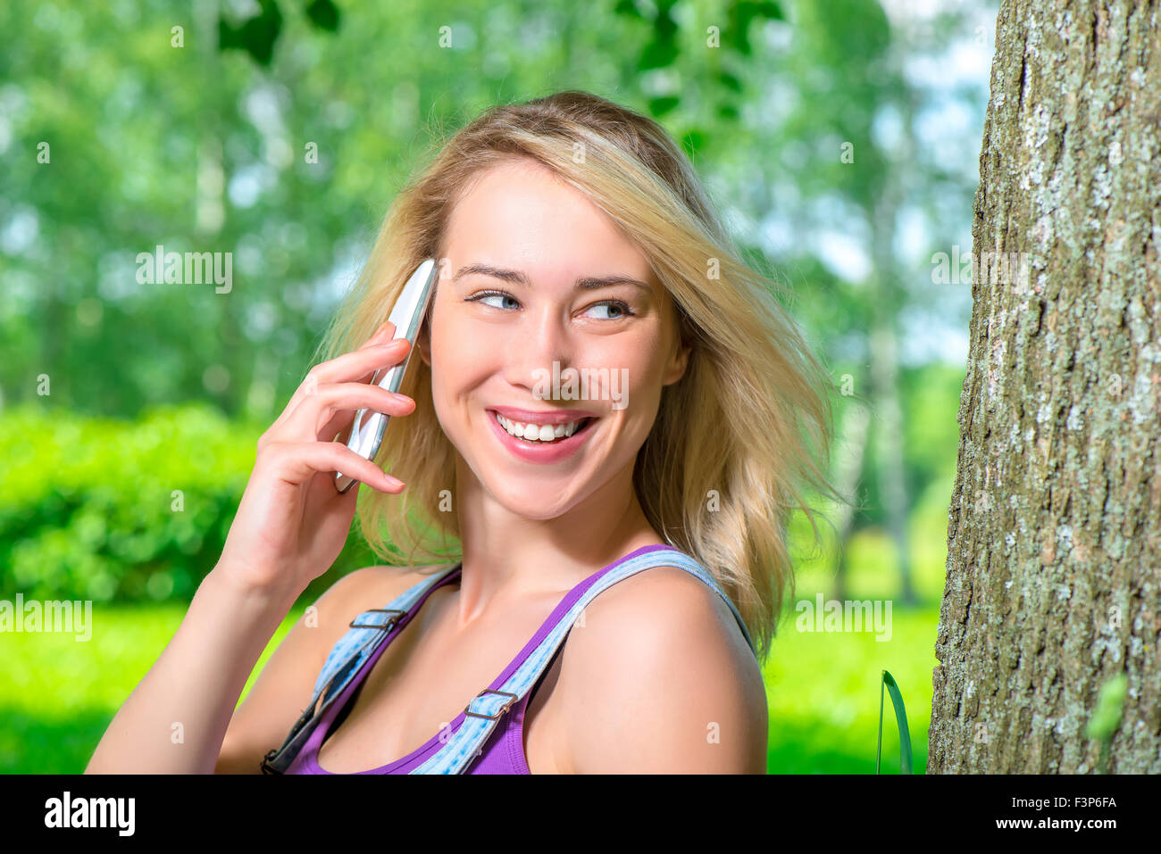 girl talking on the phone near a tree in the park Stock Photo Alamy