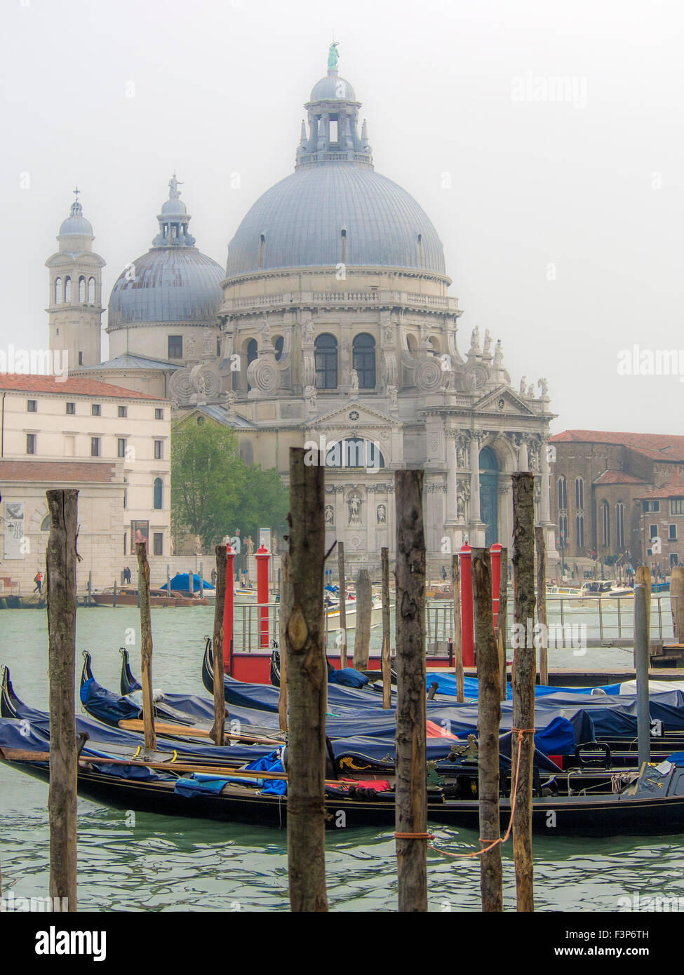VENICE, ITALY - MAY 05, 2015:  Gondola's moored on the Grand Canal with the Basilica of Santa Maria della Salute in the background Stock Photo