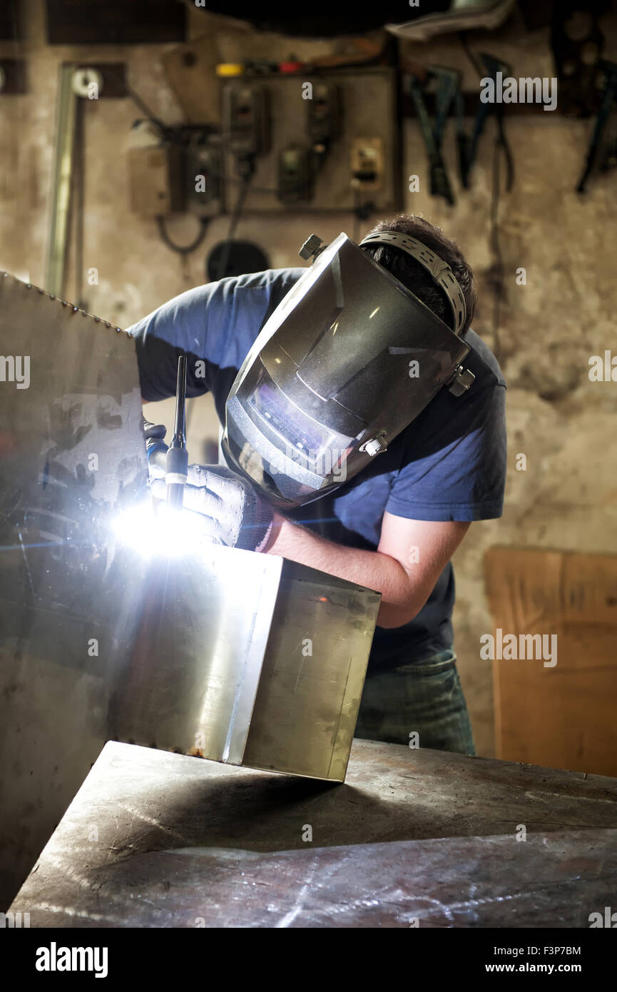 Welder welding sheet metal in a workshop Stock Photo