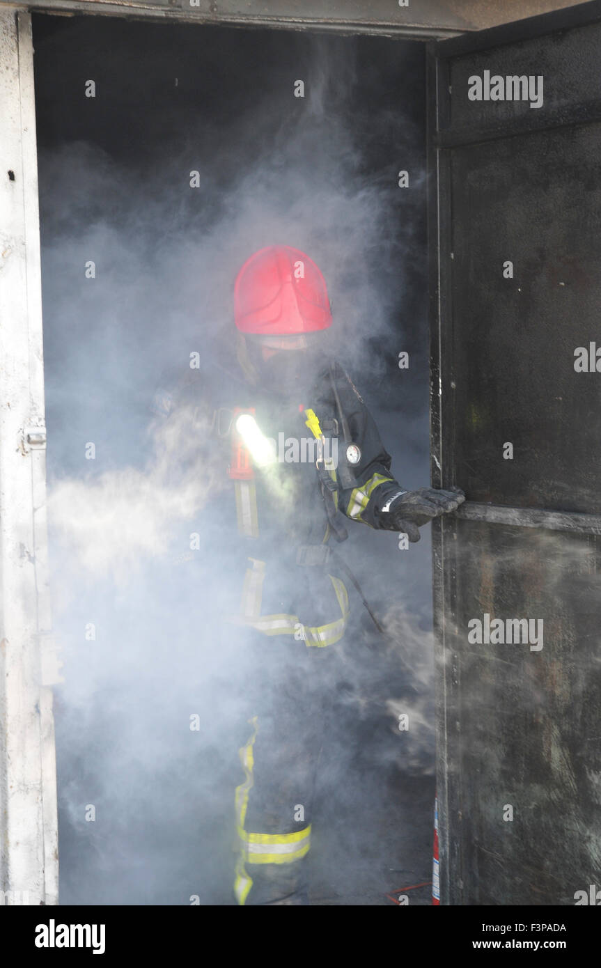 Firefighters with protective equipment in a smoke filled room Stock Photo