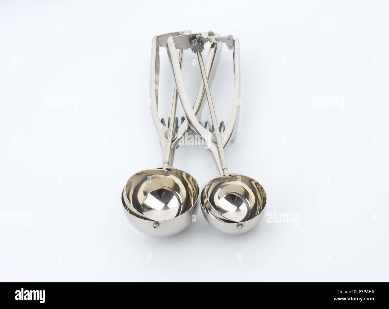 two silver ice cream scoops on white background Stock Photo Alamy