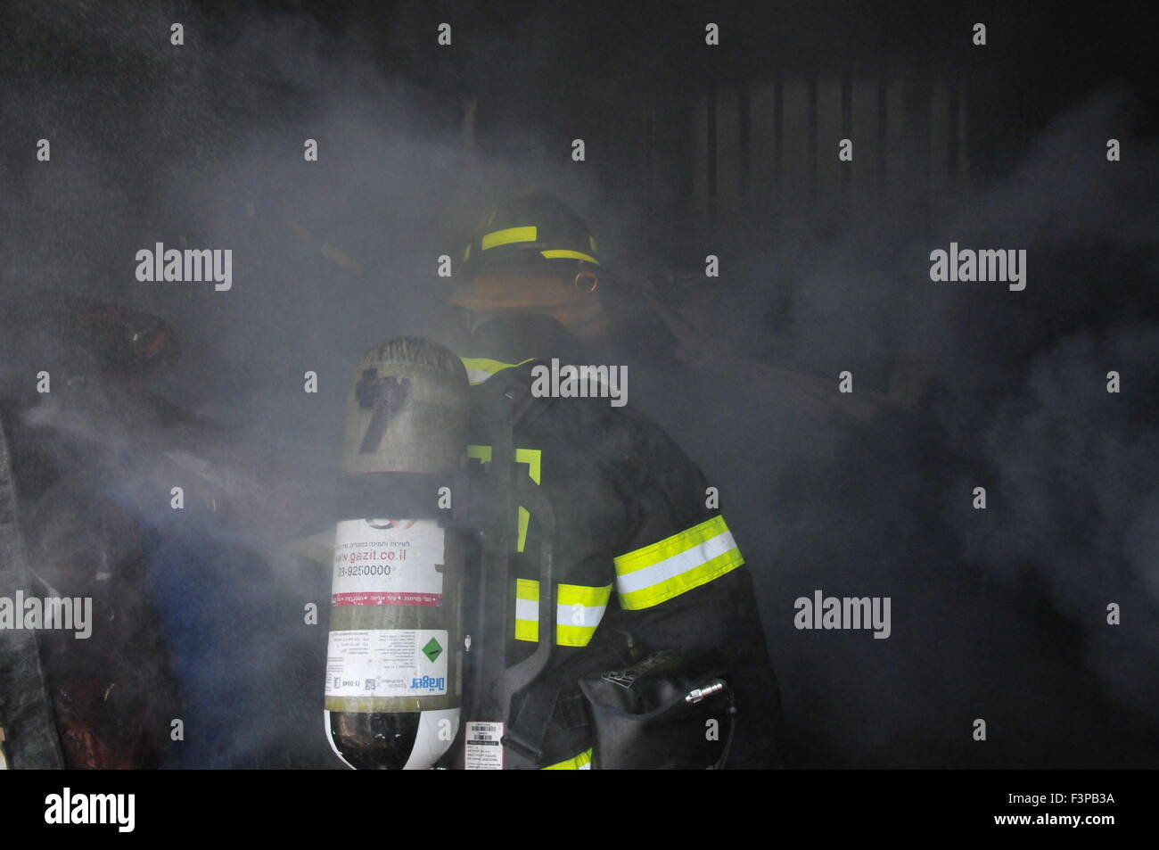 Firefighters with protective equipment in a smoke filled room Stock Photo